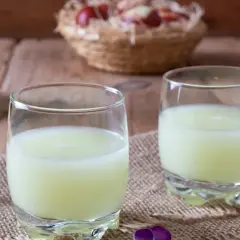 Żętyca, co to jest? To serwatka, lekki napój z mleka, podana w szklankach z kwiatami.