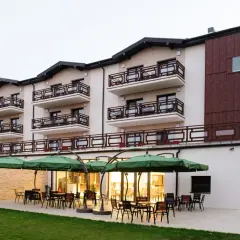 Nowoczesny hotel w Ciechocinku, Teodorka, z tarasem i zielonymi parasolami.
