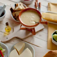 Pyszne fondue serowe z dodatkami: pieczywo, warzywa i kawałek sera. Idealny wybór, jaki ser do fondue?