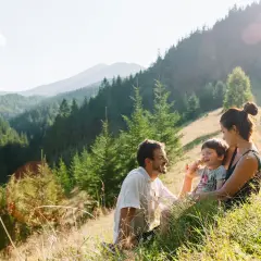 Rodzina odpoczywa na trawie, podziwiając najpiękniejsze szlaki w Beskidach.