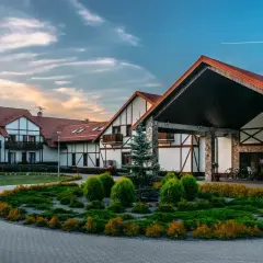 Hotel Mikołajki Leisure & Spa zaprasza do wypoczynku. Piękny budynek z kamiennymi elementami i zadbanym ogrodem.