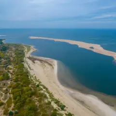 Piękne, piaszczyste plaże i spokojne wody - idealne na tanie miejscowości nad morzem. Długi, piaszczysty cypel otoczony zielenią i błękitem.