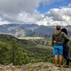 Para zakochanych podziwia malowniczy krajobraz podczas trekkingu na Gran Canarii. Góry, lasy i chmury tworzą spektakularny widok.