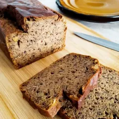 Pyszny, wilgotny chlebek bananowy bezglutenowy, pokrojony na desce z drewna. Idealny na zdrowe śniadanie.