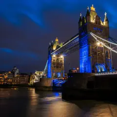Tower Bridge w Londynie, jedna z głównych wielka brytania atrakcje, nocą, oświetlona na niebiesko.