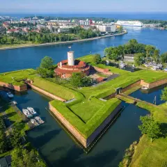 Twierdza Wisłoujście w Gdańsku – ciekawe miejsce do zwiedzenia, otoczone fosą i zielenią, z widokiem na port.