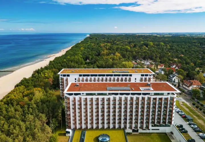 Pinea Resort Pobierowo, nowoczesne budynki hotelowe z widokiem na morze i las.