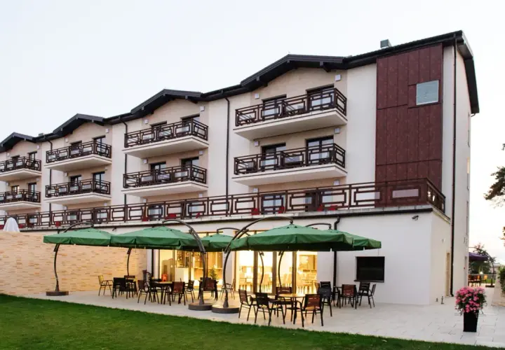 Nowoczesny hotel w Ciechocinku, Teodorka, z tarasem i zielonymi parasolami.
