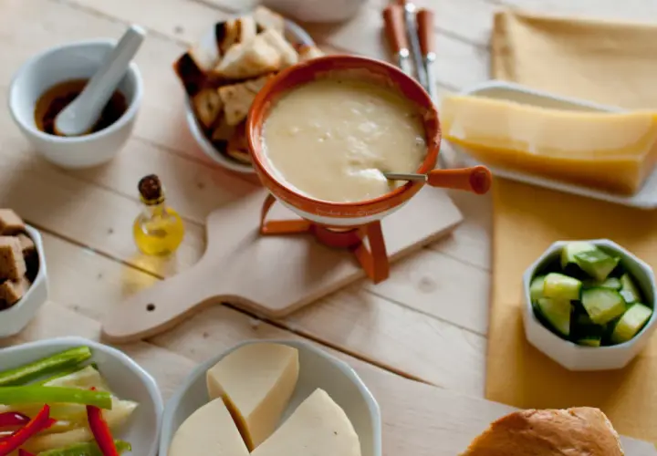 Pyszne fondue serowe z dodatkami: pieczywo, warzywa i kawałek sera. Idealny wybór, jaki ser do fondue?