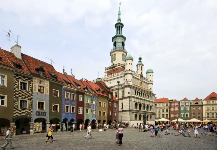 Kolorowy Rynek w Poznaniu, jedno z miejsc, które pokazują, jakie miasta warto zwiedzić w Polsce. Tętniący życiem plac z ratuszem i kamieniczkami.