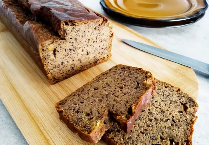 Pyszny, wilgotny chlebek bananowy bezglutenowy, pokrojony na desce z drewna. Idealny na zdrowe śniadanie.