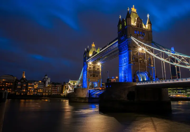 Tower Bridge w Londynie, jedna z głównych wielka brytania atrakcje, nocą, oświetlona na niebiesko.