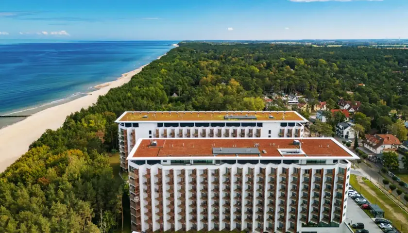 Pinea Resort Pobierowo, nowoczesne budynki hotelowe z widokiem na morze i las.