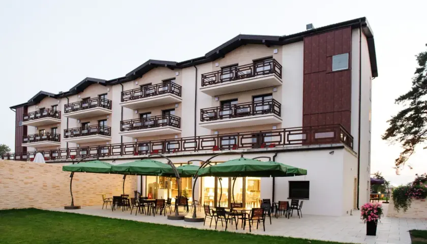 Nowoczesny hotel w Ciechocinku, Teodorka, z tarasem i zielonymi parasolami.