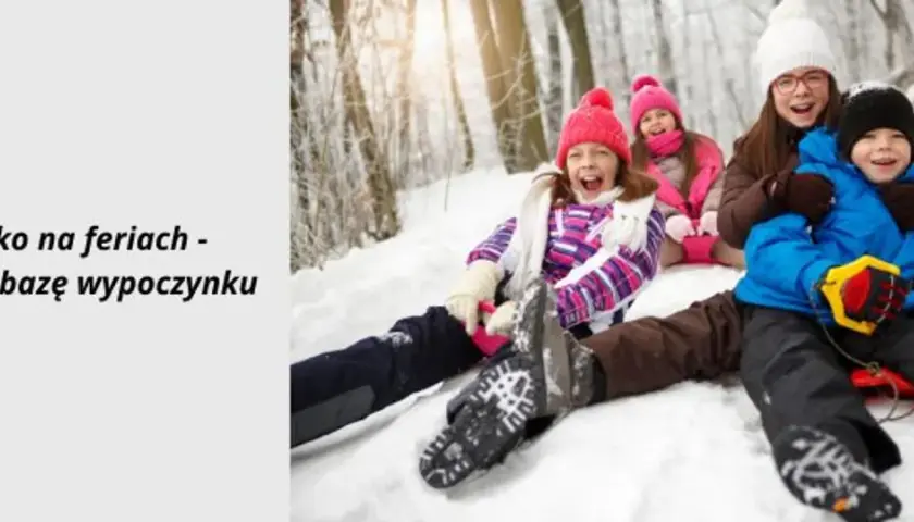 Radosne dzieci zjeżdżają na sankach zimą. Szukasz pomysłu, gdzie na ferie z dziećmi? Sprawdź bazę wypoczynku.