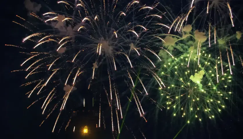 Sylwester nad morzem gdzie najlepiej? Fajerwerki rozświetlają nocne niebo nad latarnią morską, tworząc magiczną atmosferę.