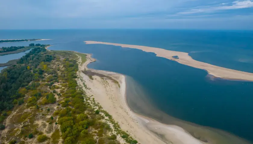 Piękne, piaszczyste plaże i spokojne wody - idealne na tanie miejscowości nad morzem. Długi, piaszczysty cypel otoczony zielenią i błękitem.