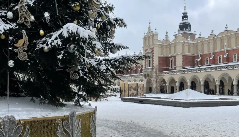 Świąteczna choinka i ośnieżone Sukiennice na Rynku Głównym. Kraków atrakcje zimą zachwycają.