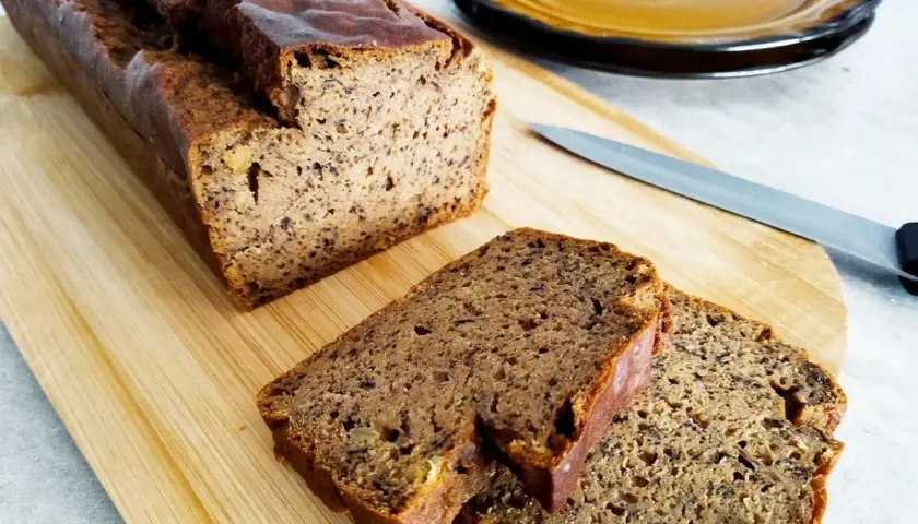 Pyszny, wilgotny chlebek bananowy bezglutenowy, pokrojony na desce z drewna. Idealny na zdrowe śniadanie.