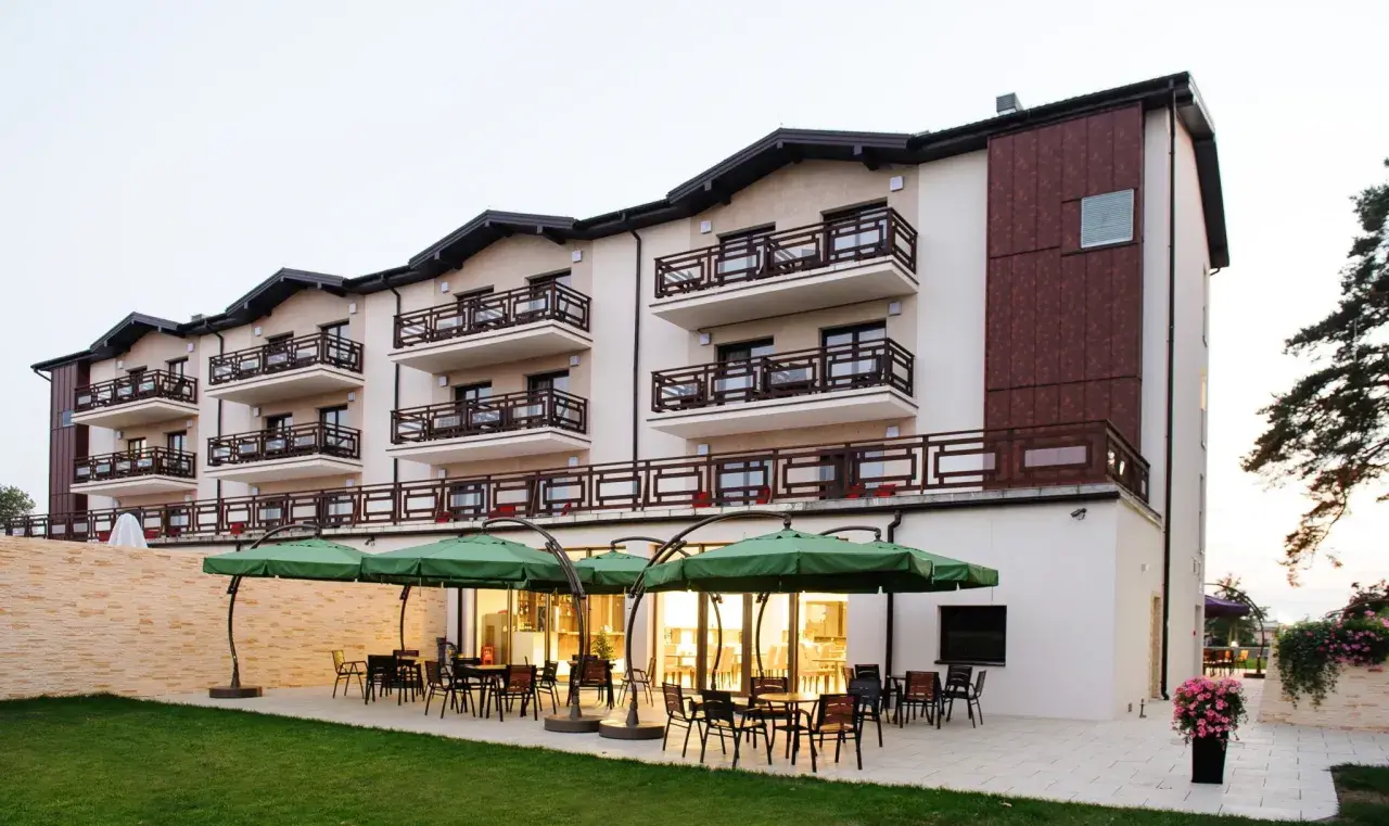 Nowoczesny hotel w Ciechocinku, Teodorka, z tarasem i zielonymi parasolami.