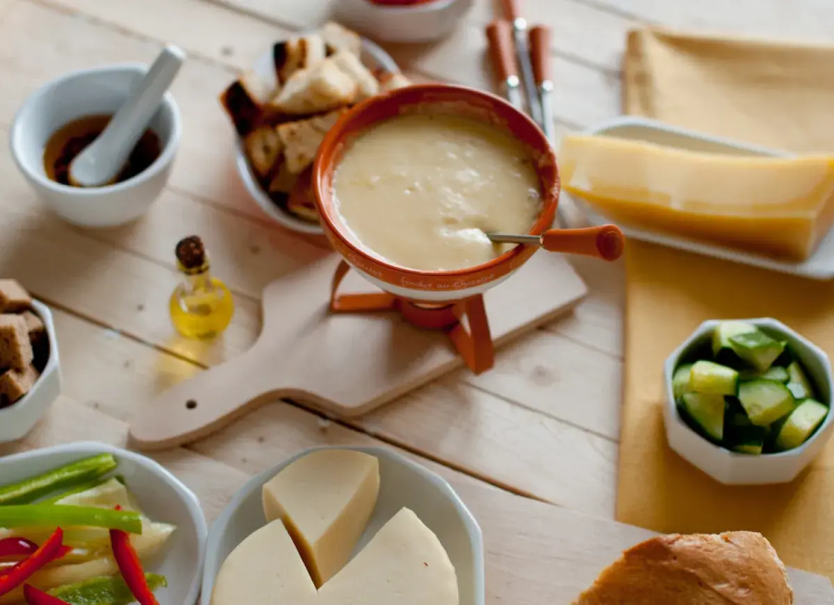 Pyszne fondue serowe z dodatkami: pieczywo, warzywa i kawałek sera. Idealny wybór, jaki ser do fondue?