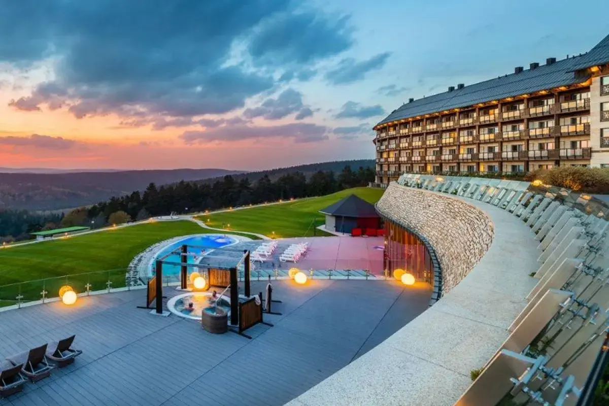 Luksusowy hotel z basenem i jacuzzi na tarasie, otoczony malowniczymi wzgórzami. To jeden z najlepszych hoteli w Polsce, idealny na relaks.