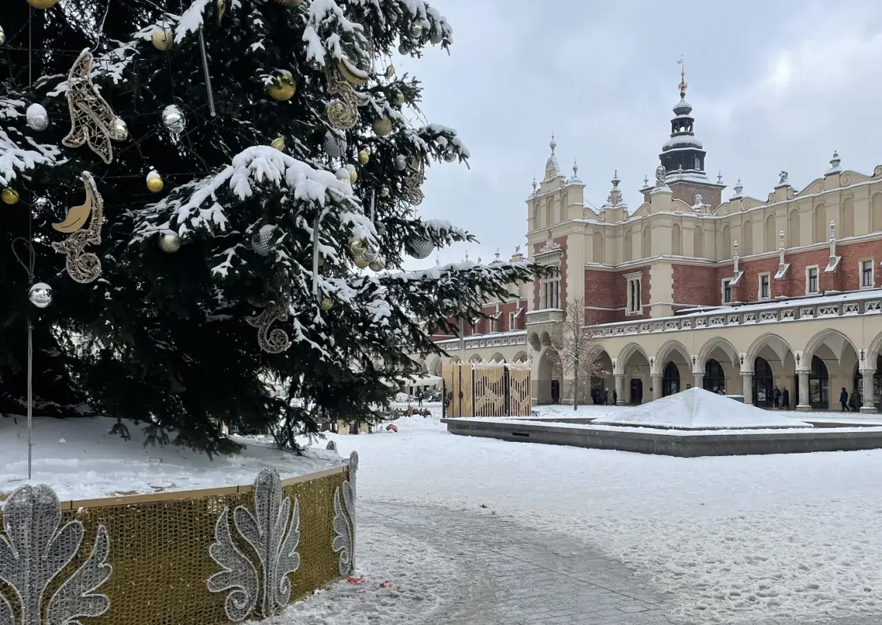 Świąteczna choinka i ośnieżone Sukiennice na Rynku Głównym. Kraków atrakcje zimą zachwycają.