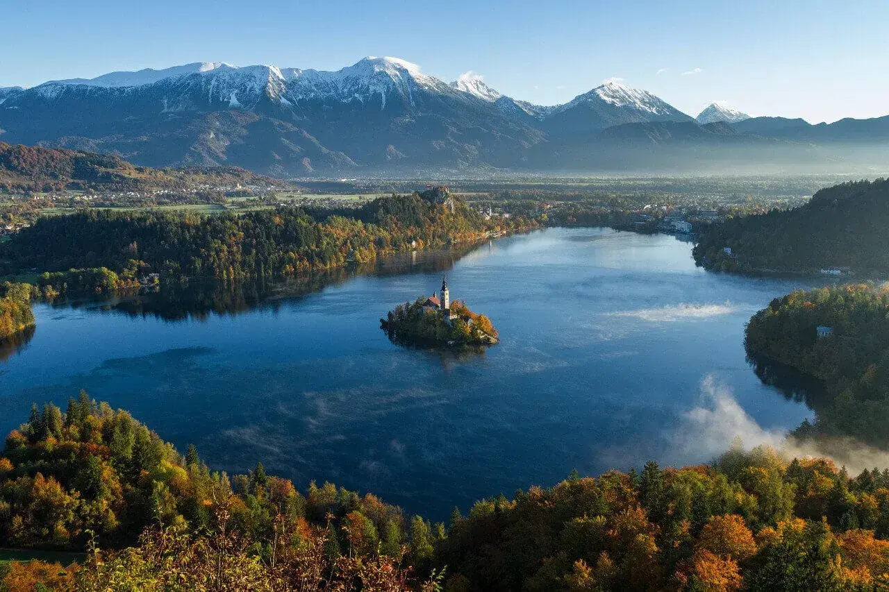 Jezioro Bled ze swoją malowniczą wyspą i kościołem to jedna z najpiękniejszych słowenia atrakcje. W tle majestatyczne Alpy.