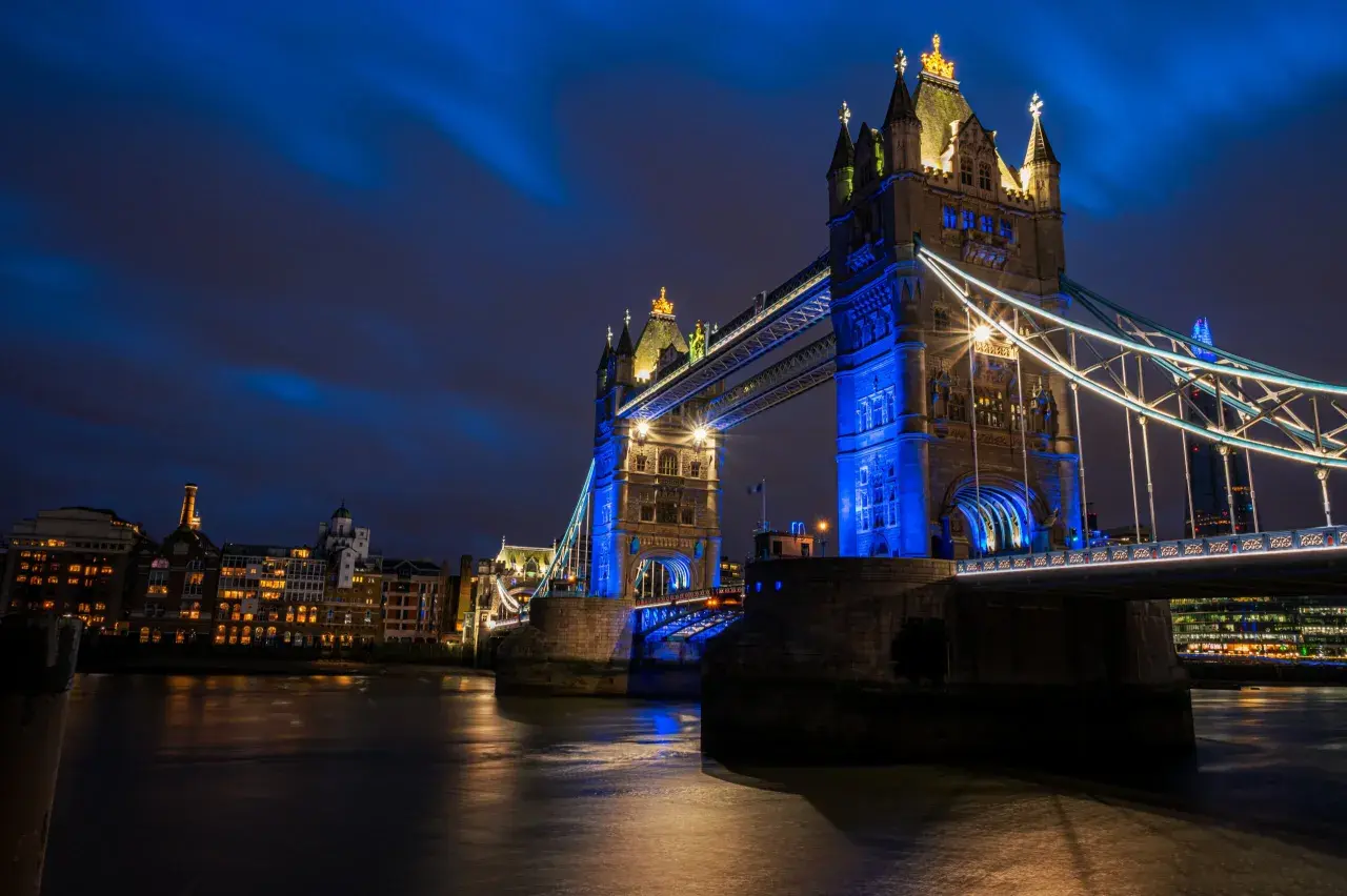 Tower Bridge w Londynie, jedna z głównych wielka brytania atrakcje, nocą, oświetlona na niebiesko.