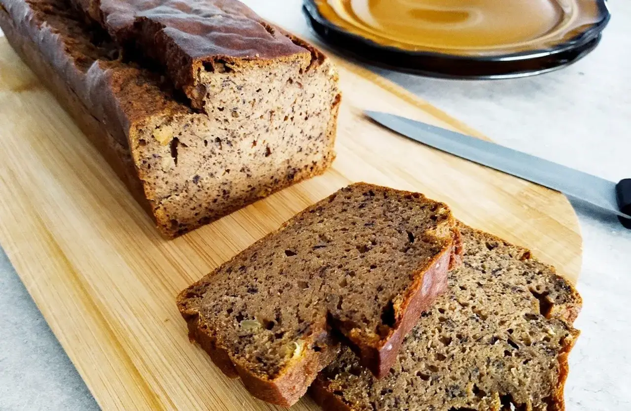 Pyszny chlebek bananowy bezglutenowy, pokrojony na desce, gotowy do podania. Idealny na zdrowe śniadanie.