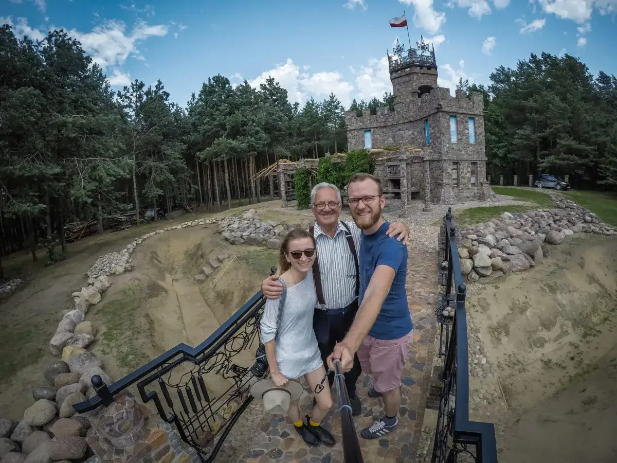 Rodzina pozuje do selfie przed kamiennym zamkiem, jednym z magicznych miejsc na Podlasiu.