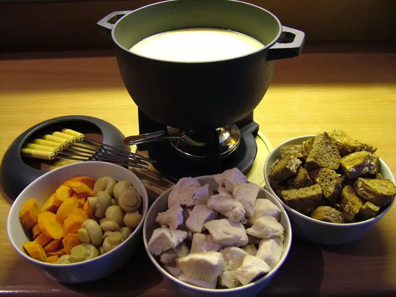 Gotowy zestaw do fondue: bulion, kawałki kurczaka, pieczarki, marchewka i grzanki. Idealny wybór, jaki ser do fondue wybrać, by stworzyć pyszne danie.