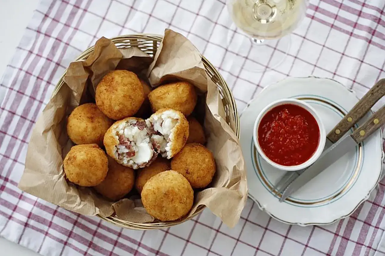 Złociste arancini, idealne na przekąskę. Ten przepis na arancini zachwyci każdego! Podane z sosem pomidorowym.