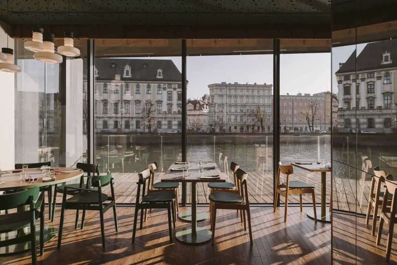 Nowoczesne wnętrze z widokiem na Odrę i zabytkową architekturę Wrocławia. Idealne miejsce na romantyczną kolację w jednej z klimatycznych restauracji Wrocławia.