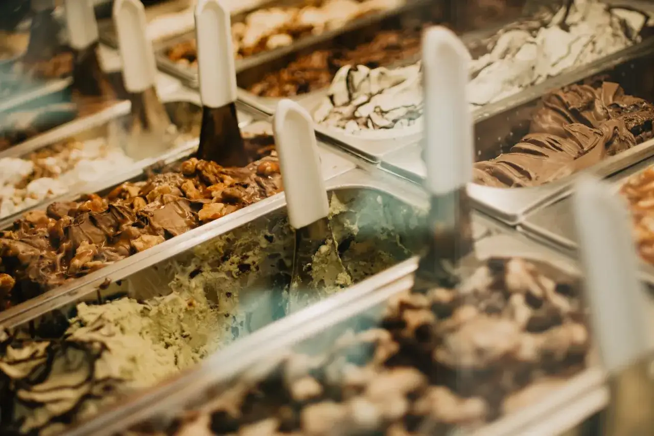 Wybierasz najlepsze lody w Warszawie? W witrynie kuszą smaki: czekoladowe, orzechowe, pistacjowe i wiele innych.