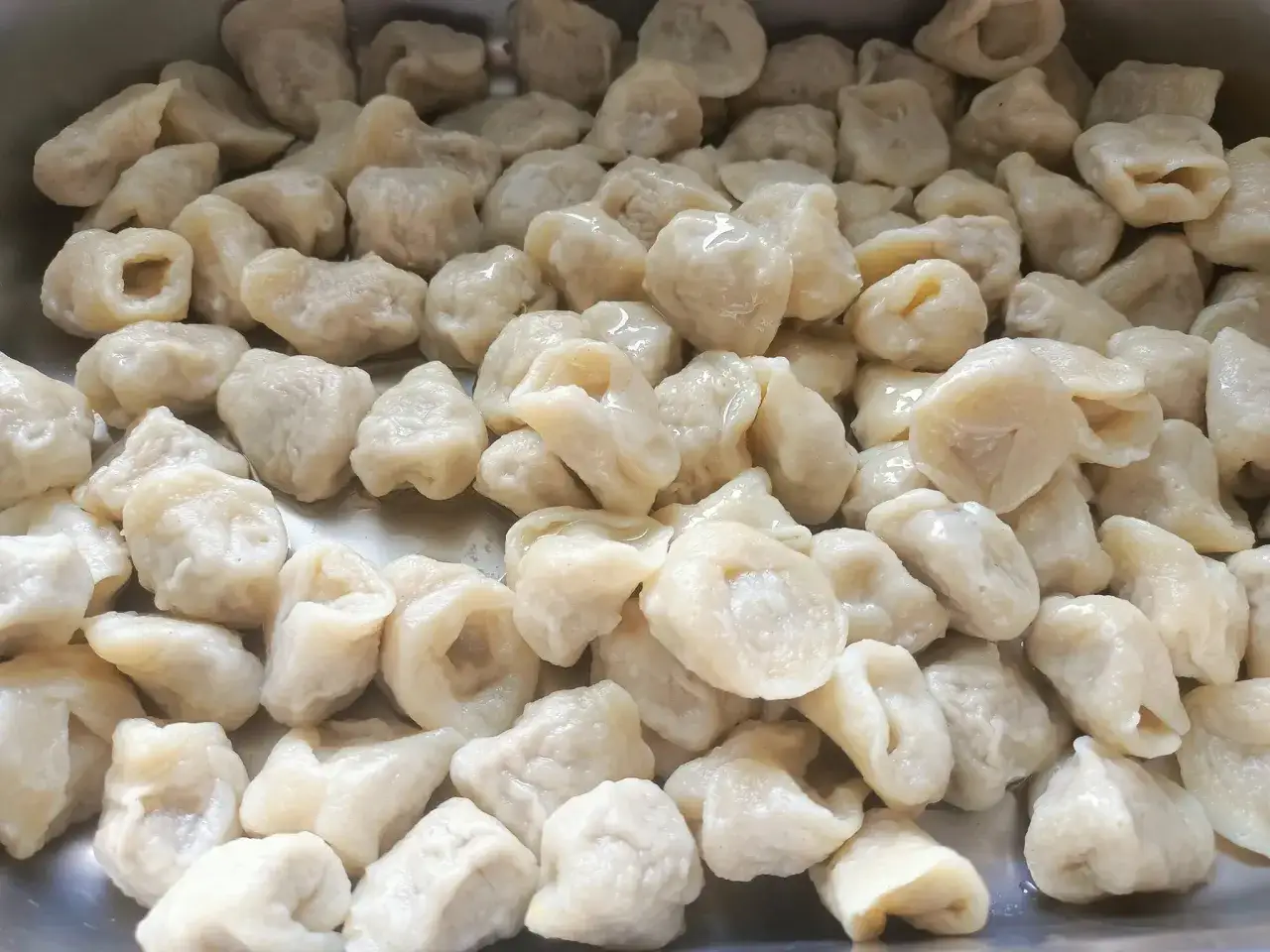 Pyszne, domowe pierogi w metalowej misce. Idealne na rodzinny obiad w jednej z ciekawych restauracji w okolicach Krakowa.