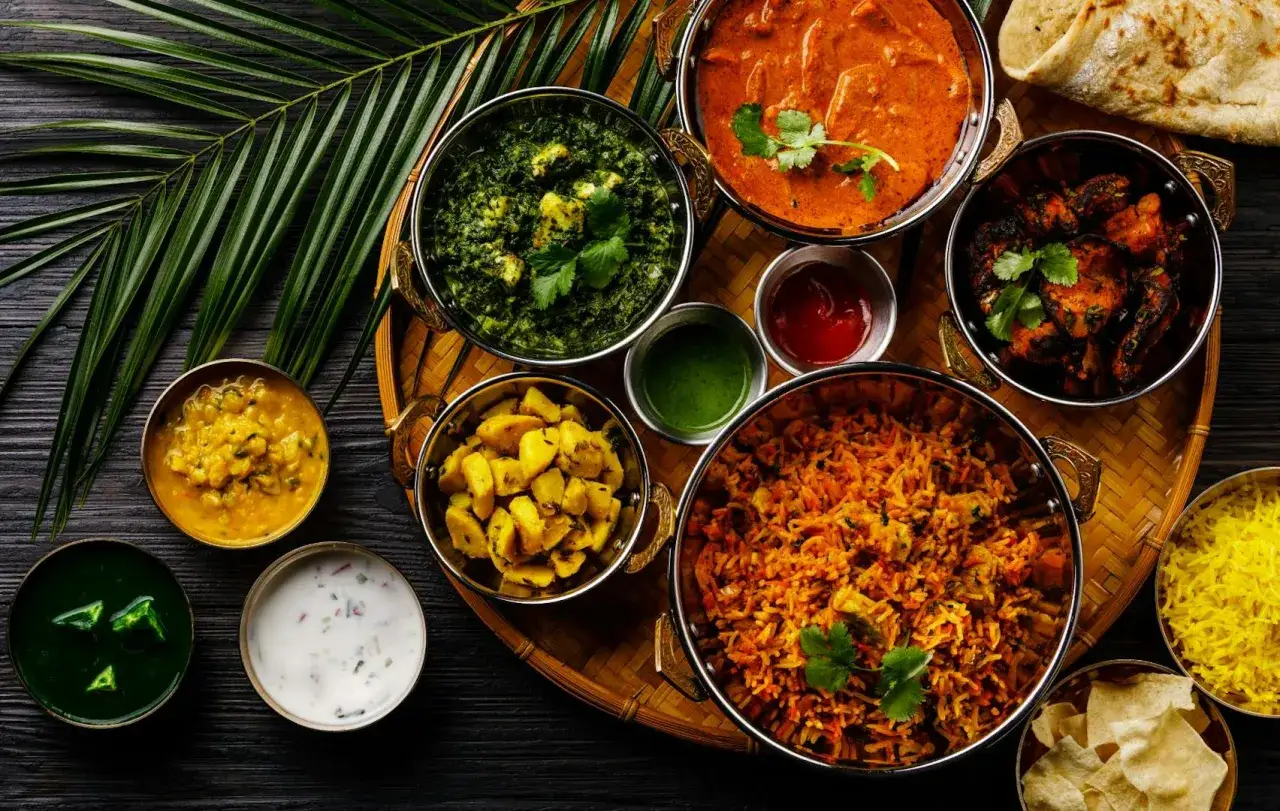 Kolorowe dania kuchni indyjskiej, takie jak curry, ryż i sosy, idealne do domowych przepisów.